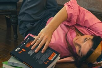 A young woman lying on the floor with her legs up a wall, illustrating the feeling of overthinking and procrastination.