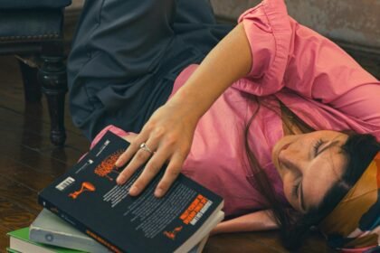 A young woman lying on the floor with her legs up a wall, illustrating the feeling of overthinking and procrastination.