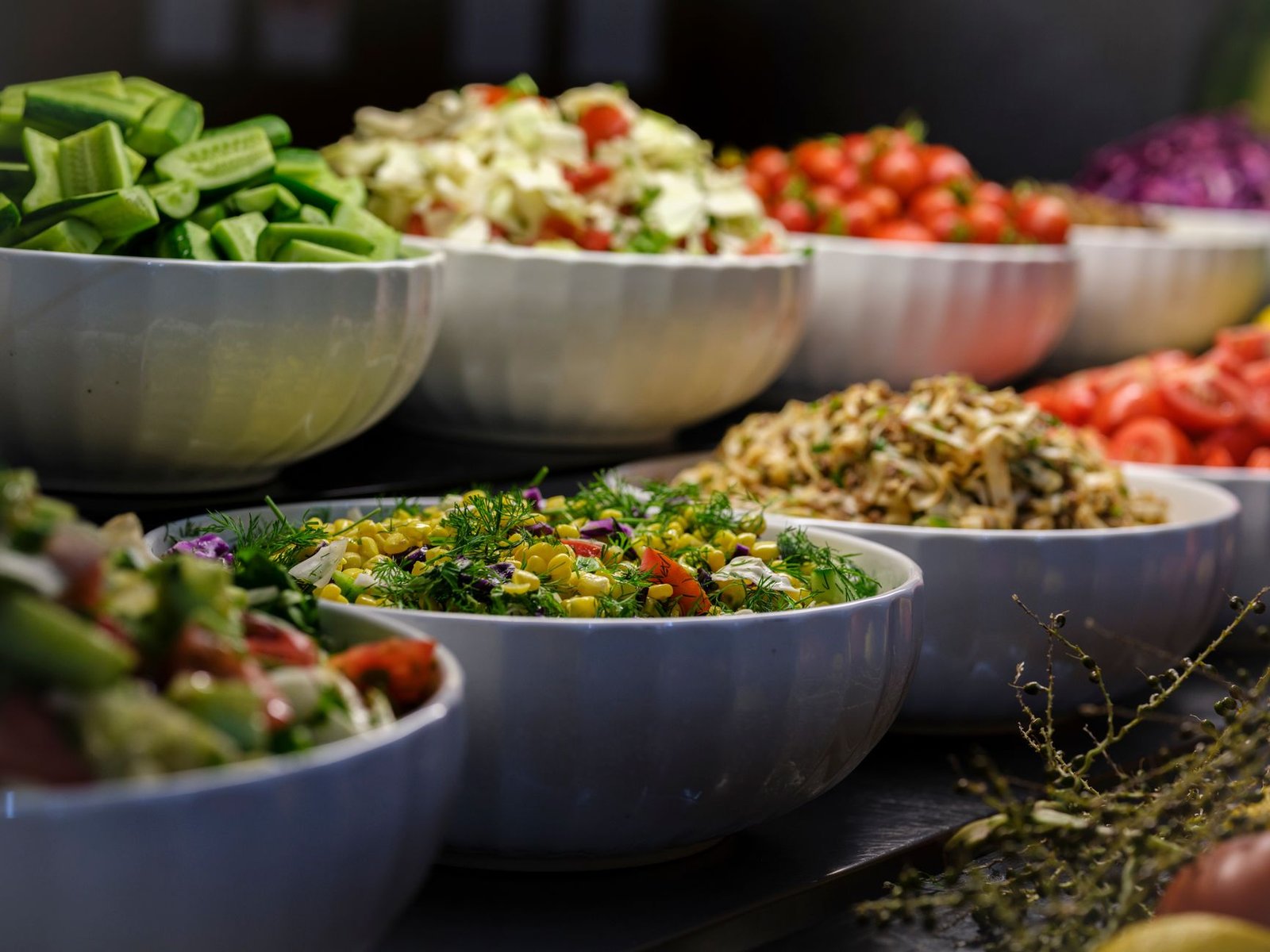Fresh vibrant salad bowl featuring leafy greens, seeds, and roasted vegetables on a rustic table.