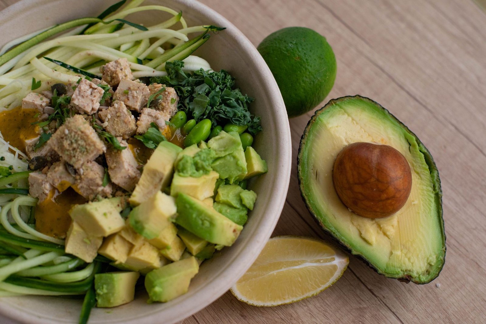 Vibrant green avocado and leafy salad in a ceramic bowl.