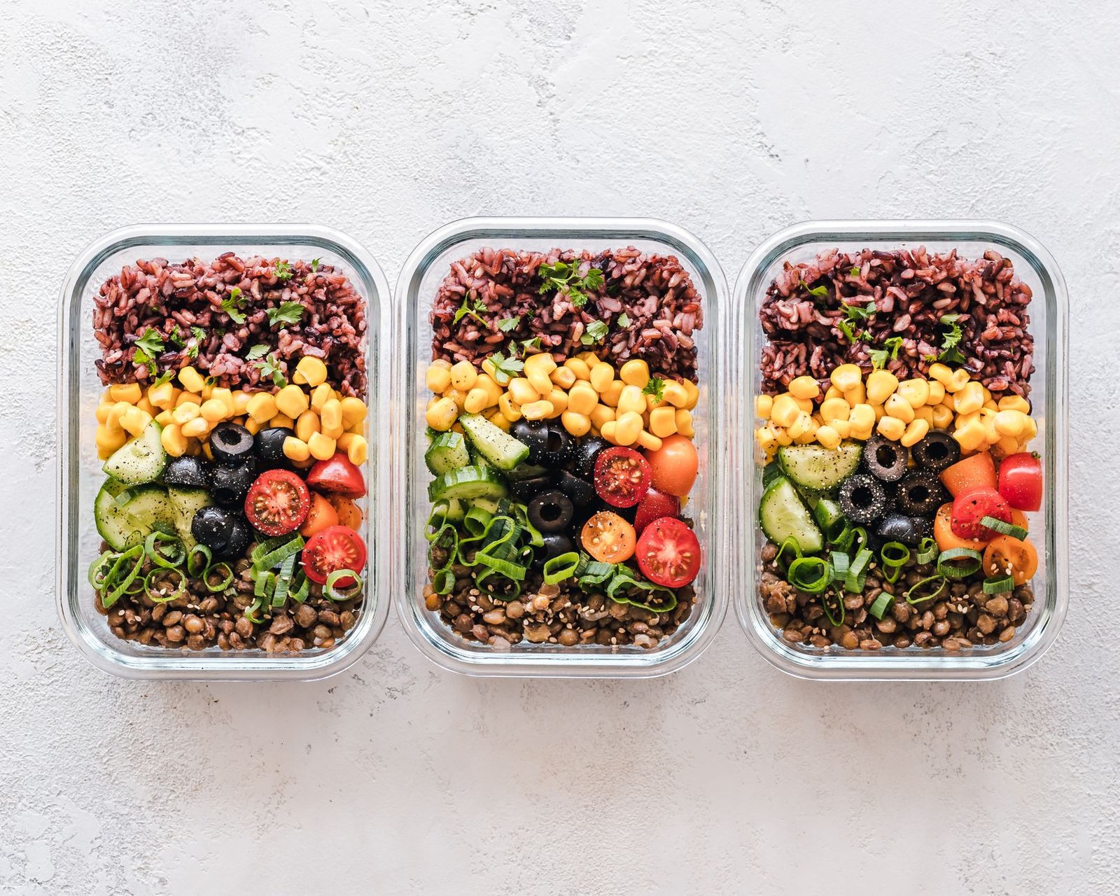 Fresh meal prep containers filled with salmon and leafy greens.