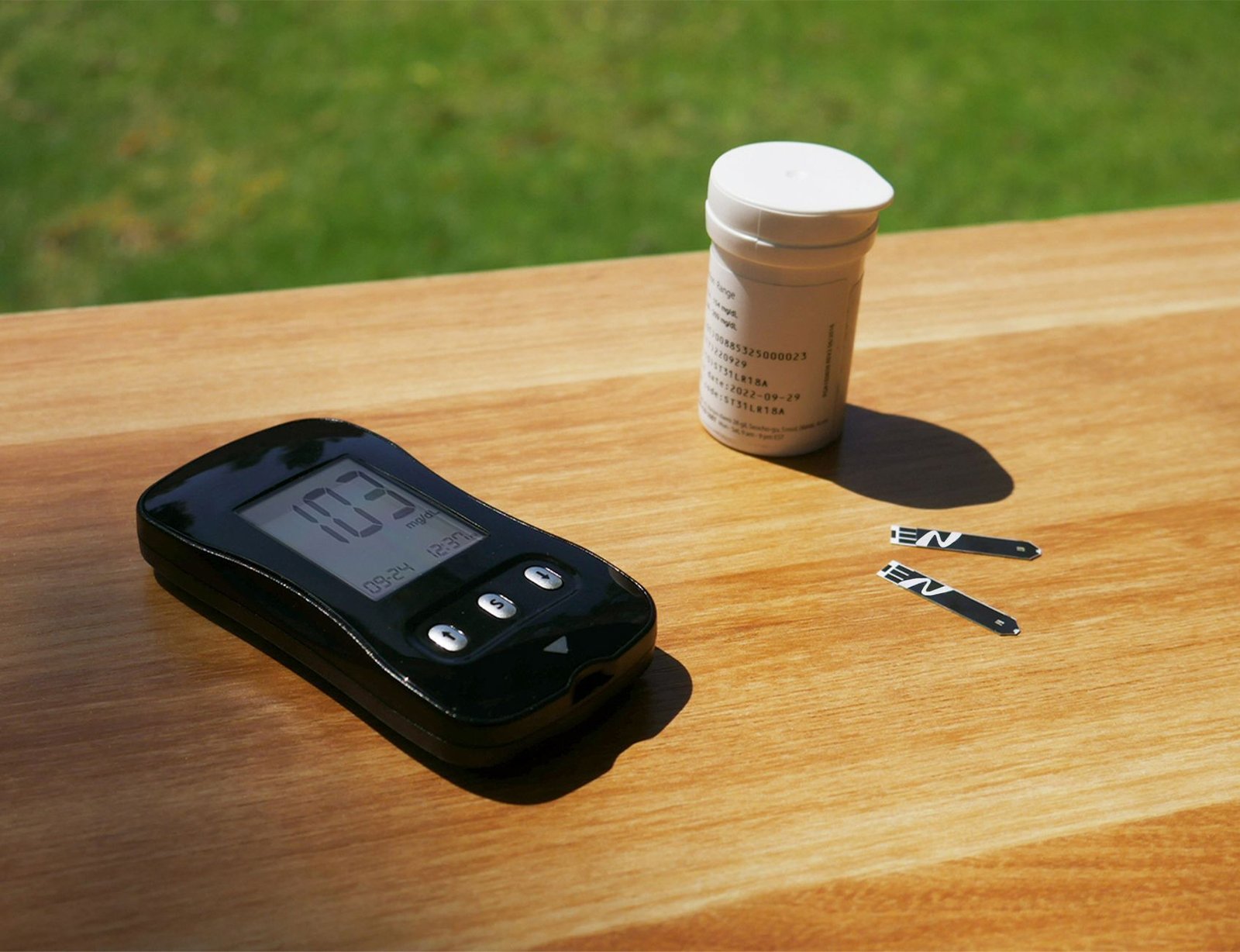Precision digital glucose and ketone meter setup on table.