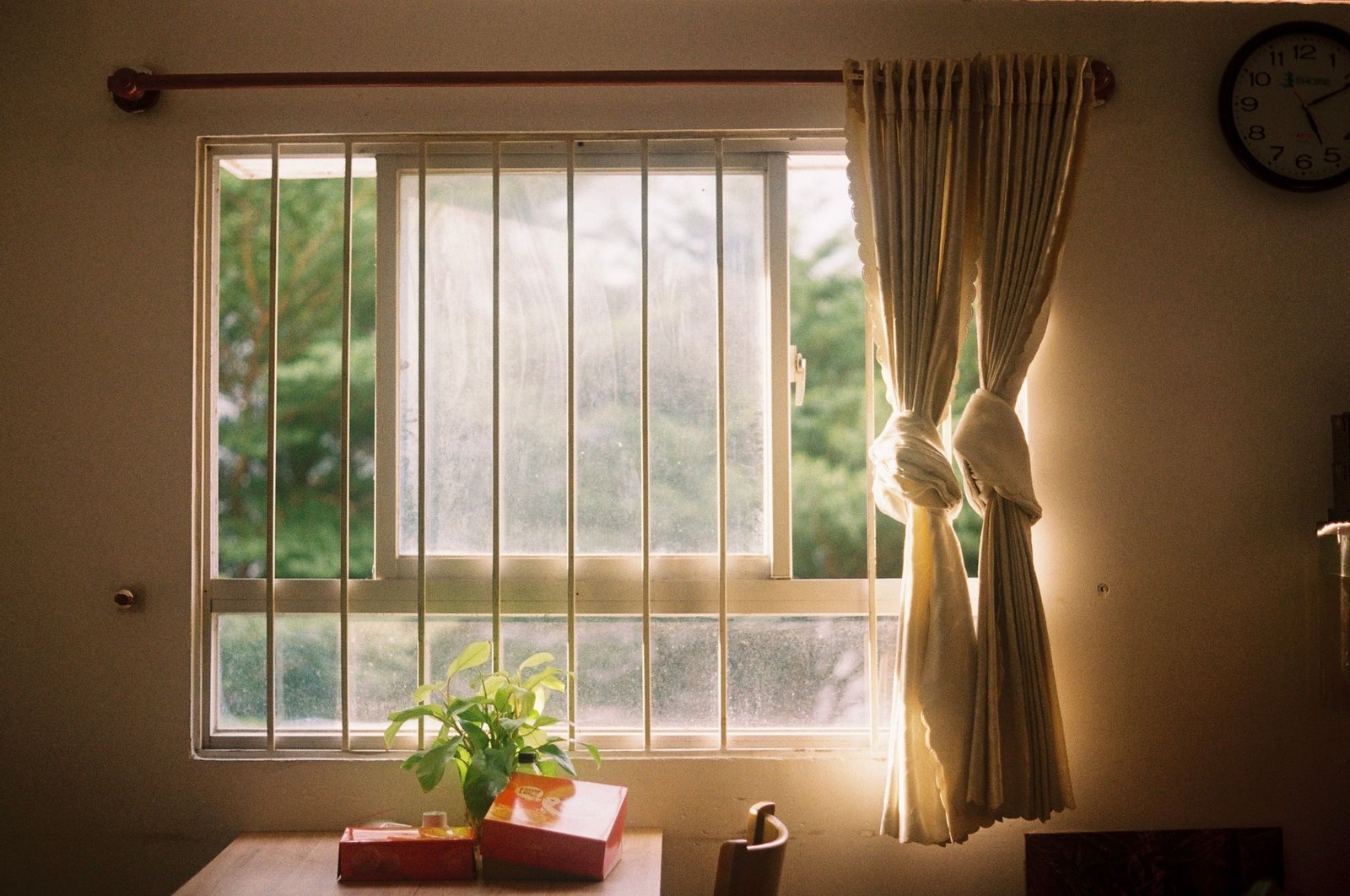 Sunlight streaming through a residential window onto a wooden dining table.
