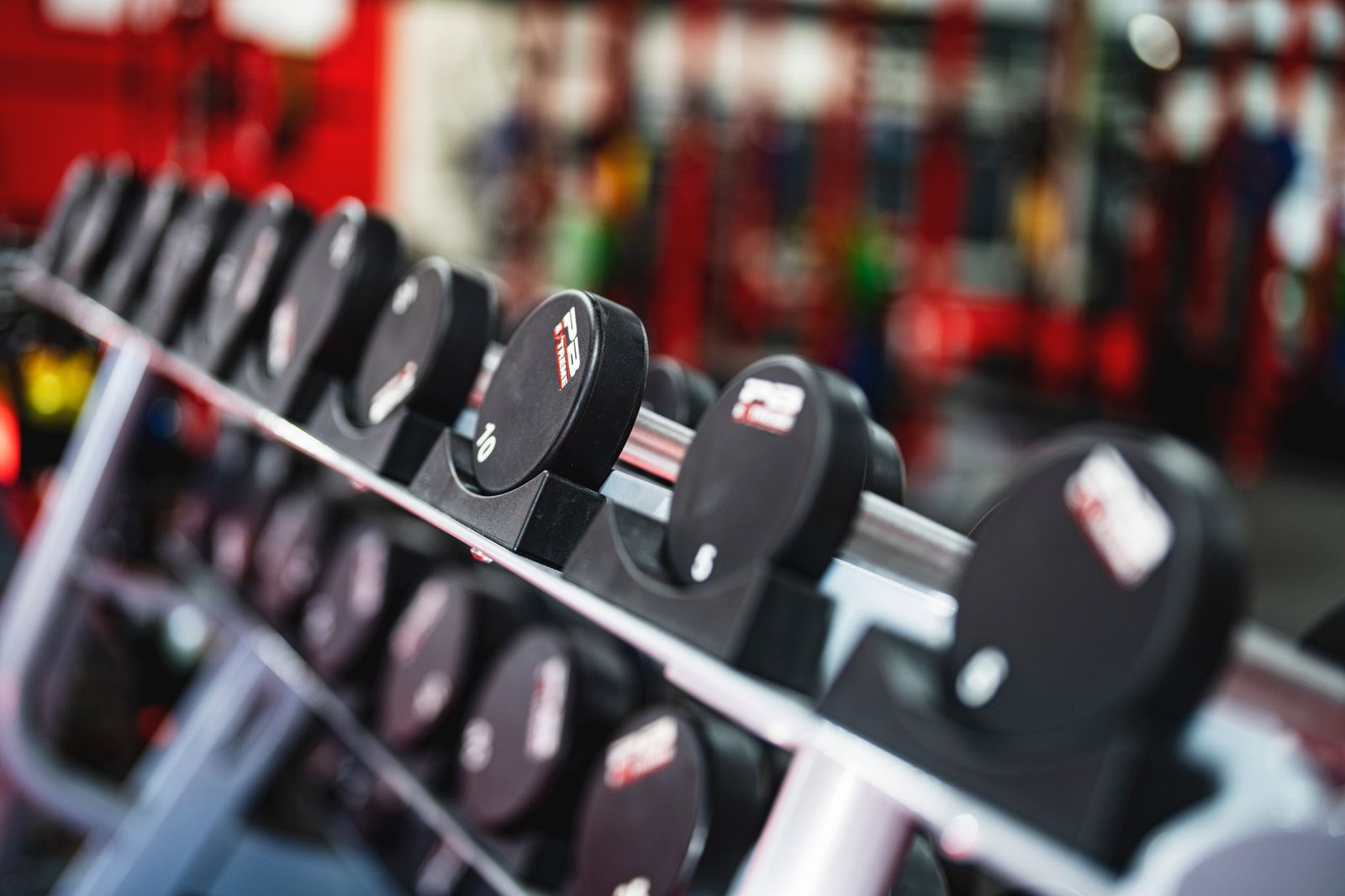 Rack of heavy dumbbells in clean and modern fitness studio.