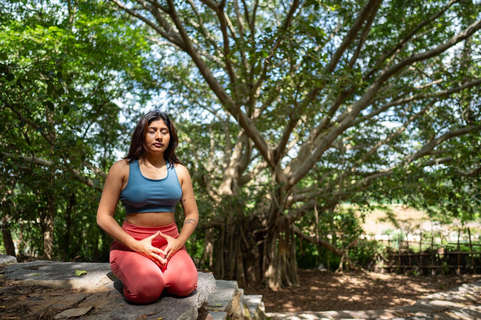A person practicing restorative breathing exercises in a tranquil outdoor setting.