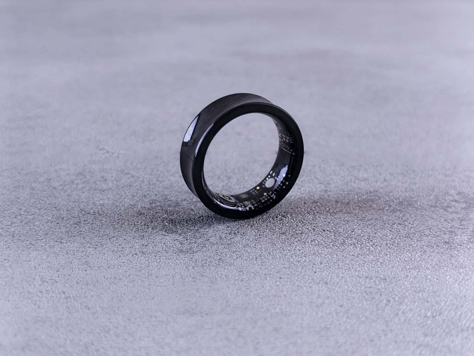 Wearable biometric ring displaying sleep tracking data on mobile screen.