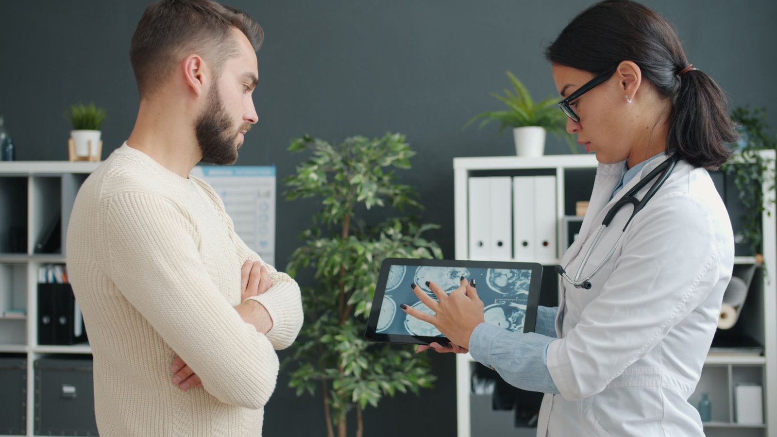 Physician discussing digital health charts with a patient in a bright clinic.