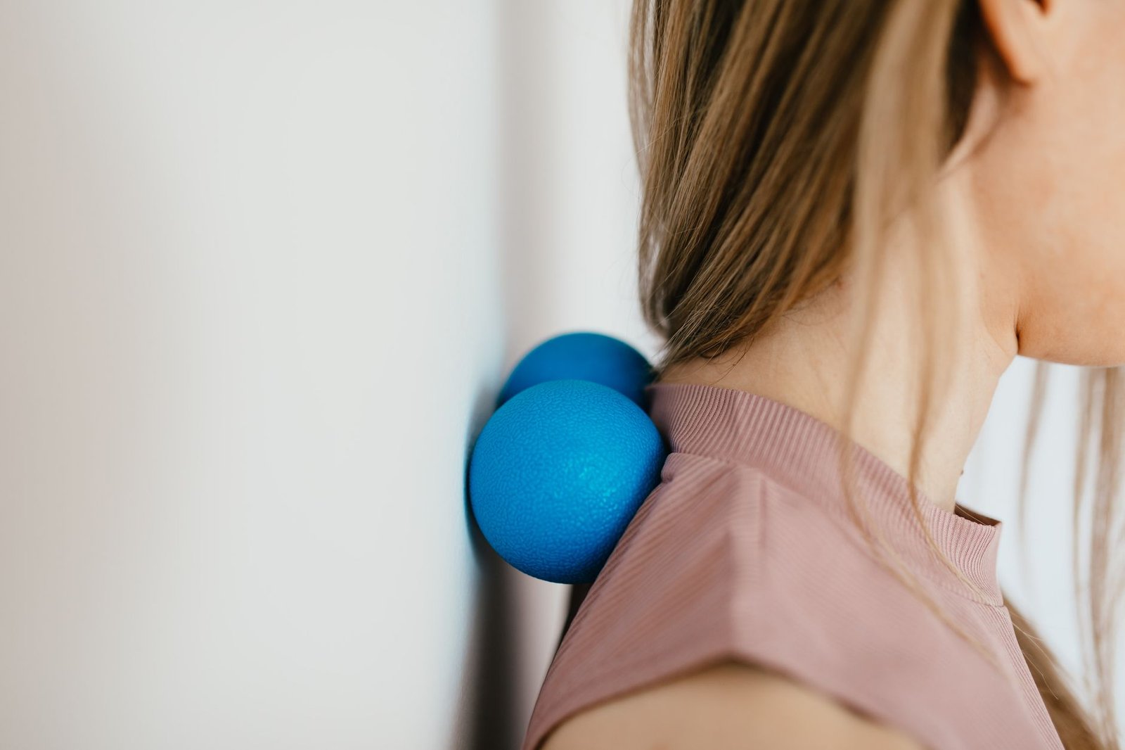A firm rubber massage ball resting on a natural cork block.