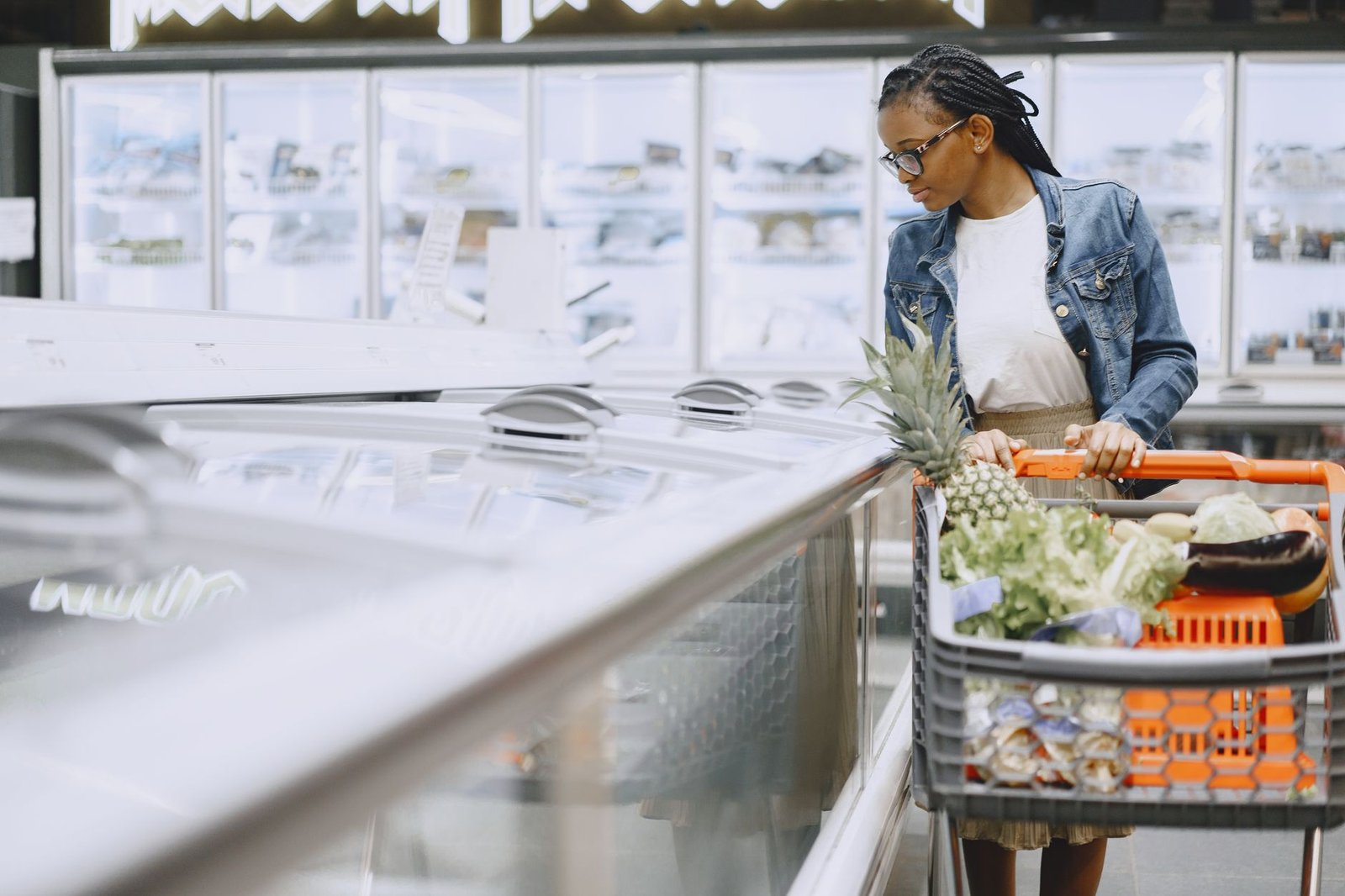 A shopper selecting fresh, affordable green produce at a neighborhood market.