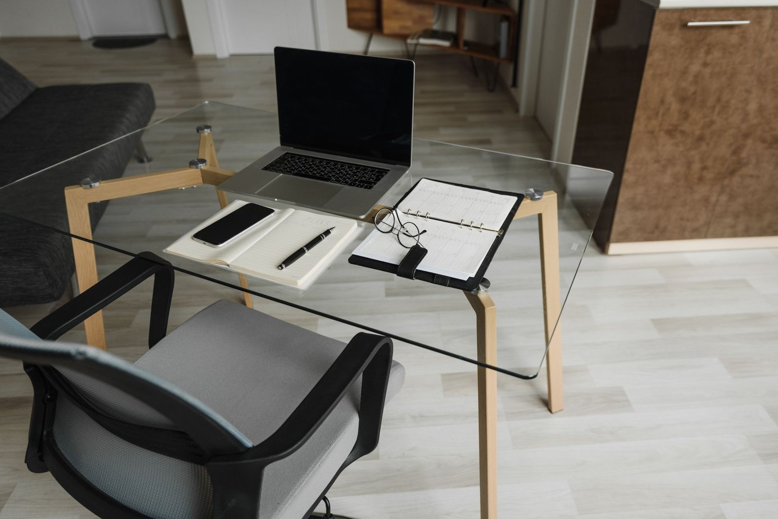Compact under-desk elliptical pedal machine positioned beneath an office chair.