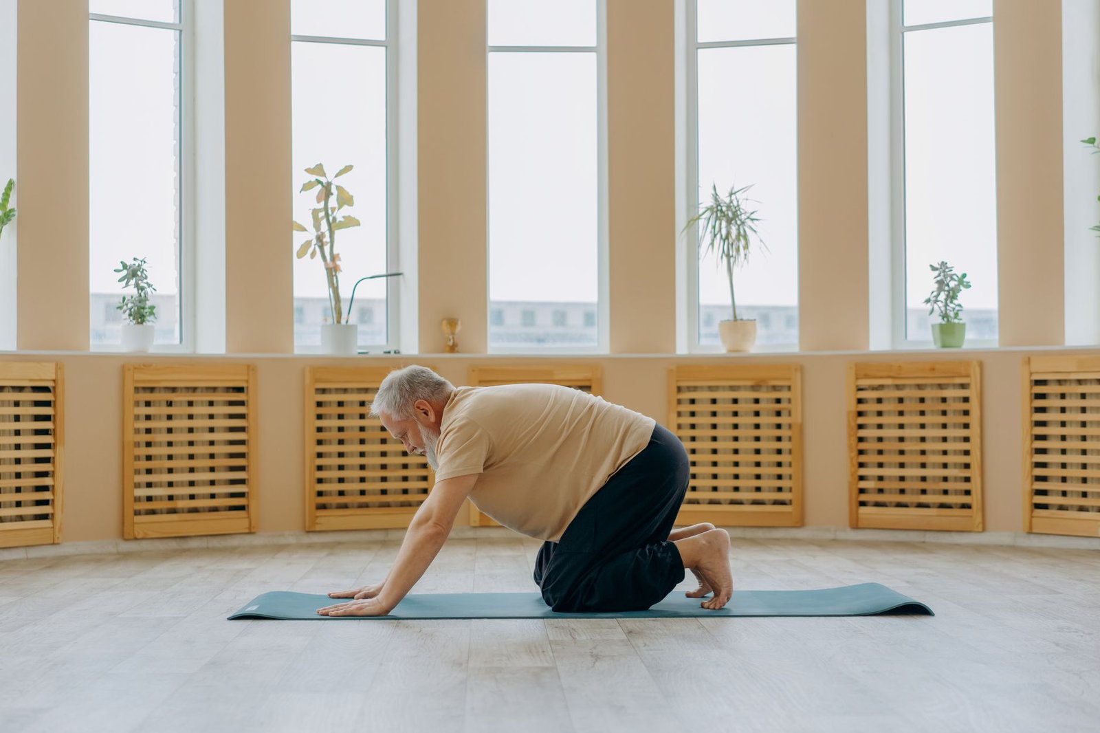 Woman performing mindful floor somatic movements in a sunlit room.
