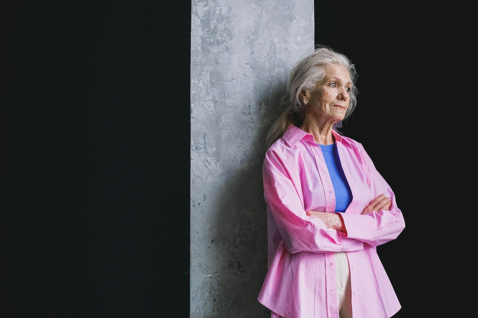 Mature woman holding a wall sit posture with focused expression indoors.