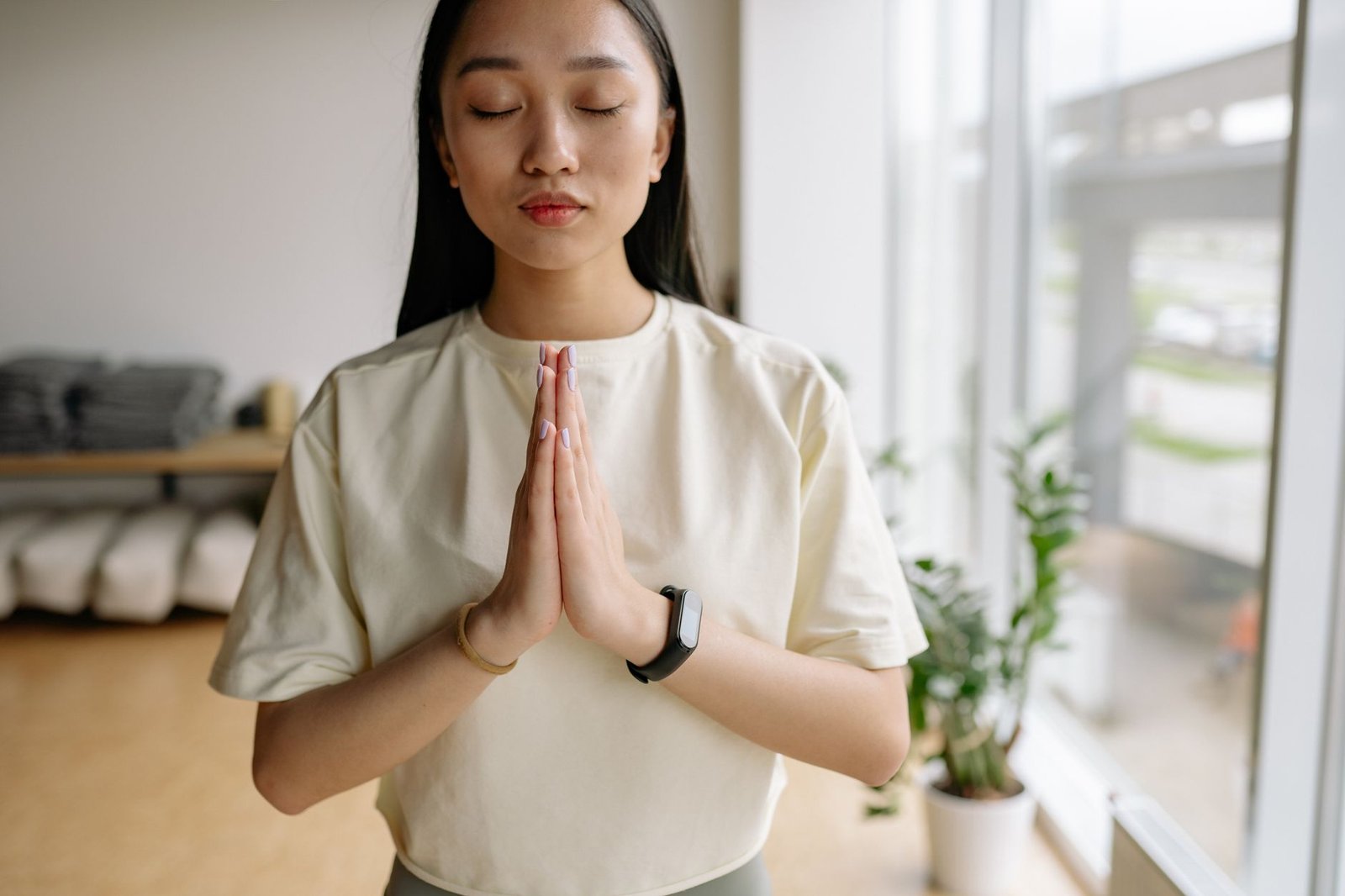 A woman practicing controlled breathing in a quiet, well-lit room.