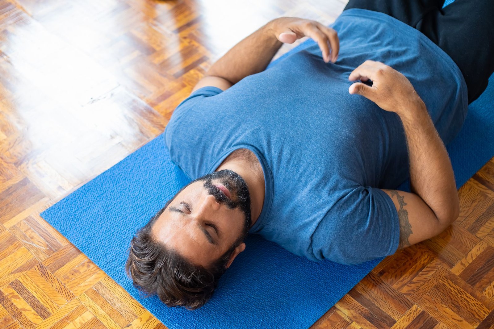 Woman performing deep physiological sigh breathing exercises in a sunlit room.